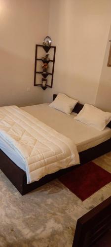 a bedroom with a large bed with white sheets at Maleyam Homestay Riverside in Kozhikode