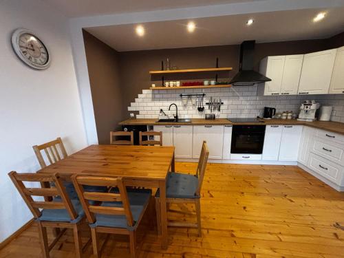 a kitchen with a wooden dining room table and chairs at Apartament Na Słowaka in Mieroszów