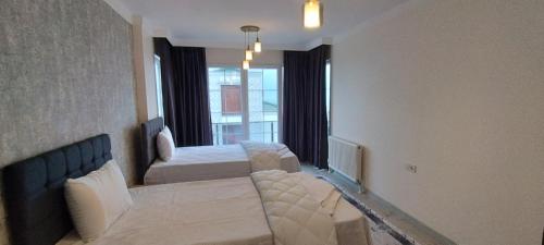 a bedroom with two beds and a large window at Nora Marmara Luxury Villas in Istanbul in Buyukcekmece