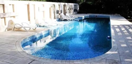 a swimming pool with blue water in a yard at Posada del Virrey in Pantanillo