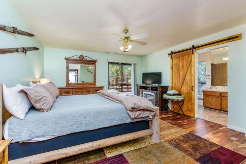 a bedroom with a large bed and a television at Stimboli Lodge- Sleeps 16 with tons of games and fun in Oakhurst