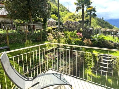 a bench sitting on a balcony with a garden at Casa Sole in Gambarogno
