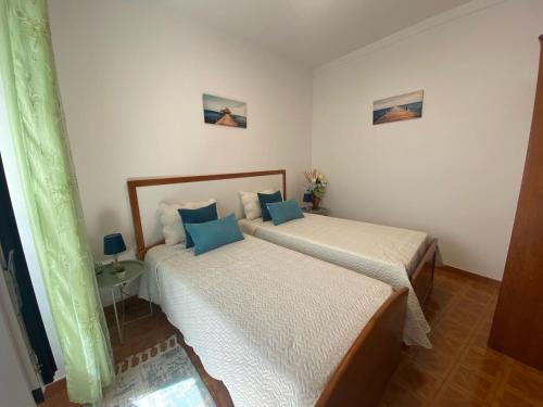 a bedroom with two beds and a table at Casa São Marcos in Peniche