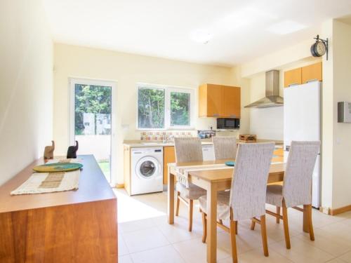 eine Küche und ein Esszimmer mit Tisch und Stühlen in der Unterkunft Casa Aromas do Mar, Burgau in Burgau