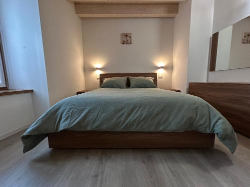 a bedroom with a large bed with two lights at FLO Homestay in Levico Terme