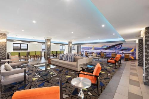 a hotel lobby with couches and tables and chairs at Best Western Inn & Suites - Midway Airport in Burbank