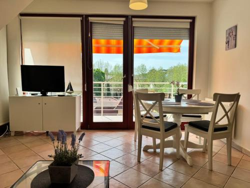 a living room with a table and chairs and a television at Sári Apartman in Siófok