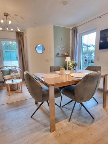 a dining room with a wooden table and chairs at Düne 4 - Ferienunterkunft mit eigenem Garten in der beliebten Dünenresidenz - sanftes Meeresrauschen inklusive in Ostseebad Karlshagen