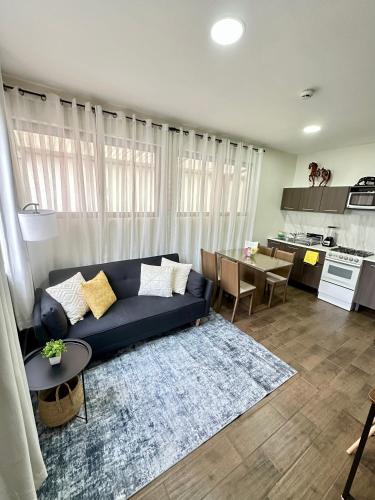 a living room with a blue couch and a kitchen at Departamento Roma 1 CDMX in Mexico City
