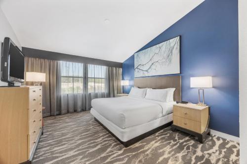 a bedroom with a large bed and a blue wall at DoubleTree Suites by Hilton Hotel Huntsville South in Huntsville