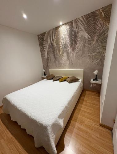 - une chambre avec un lit blanc et un papier peint tropical dans l'établissement Andromède, à Ensuès-la-Redonne