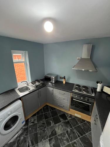 a kitchen with a stove and a sink in it at Charlies in Skegness