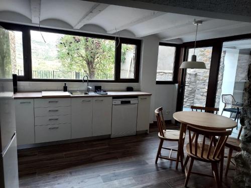 a kitchen with a table and a table and chairs at Casa Chumpón in La Puebla de Roda