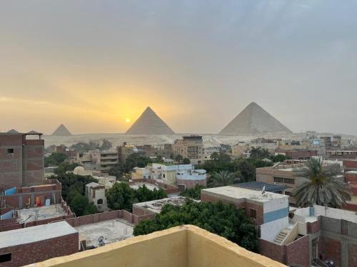 a view of the pyramids from the roofs of a city with buildings at Eyad Pyramids view in Cairo