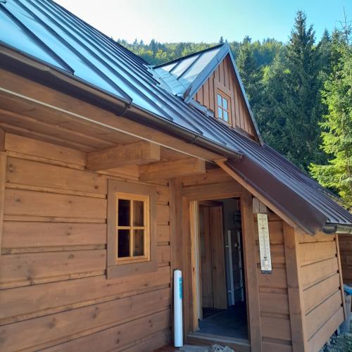 a wooden cabin with a gambrel roof at Rekreačná chata in Banská Bystrica