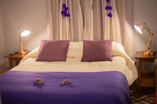 a bedroom with a bed with two flowers on it at Estación Tilcara boutique hotel in Tilcara