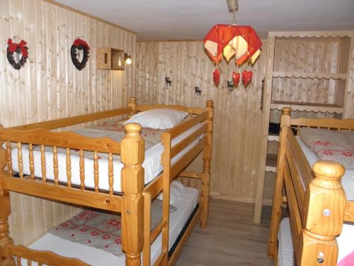 Ce lit se trouve dans un dortoir doté de 2 lits superposés et de murs en bois. dans l'établissement Gîte Auberge Les Terres Blanches de Méolans, à Méolans