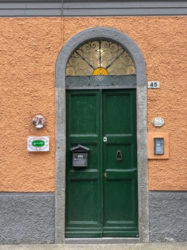 a green door in a building with an orange wall at C'era un Voltino Guest House in Borgonovo