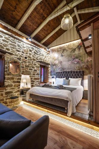 a bedroom with a large bed in a stone wall at Archontiko Theofanous 1915 in Tríkala