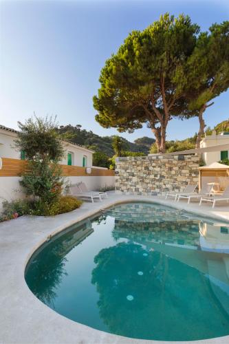 a swimming pool in a yard with chairs and trees at Erato by Samian Mare in Karlovasi