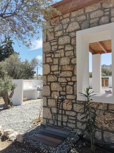 a stone wall with a shower in a house at Anasa Rustic Villa in Kolimbia