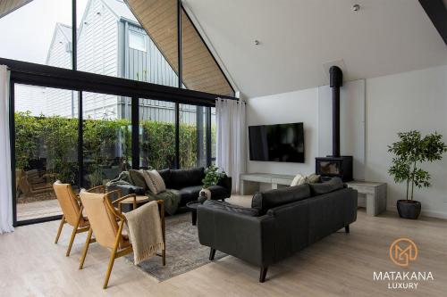 a living room with couches and chairs at Matakana Luxury Escapes in Matakana