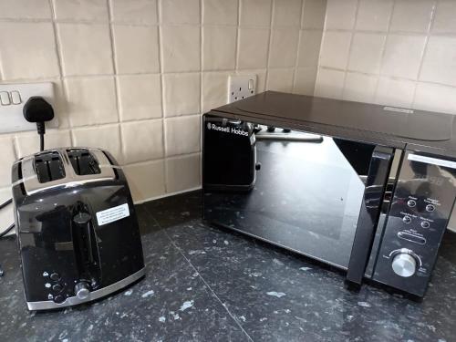 a kitchen with a table and a coffee maker and a toaster at Silverlight's Place - 2BR Home in Central Oldbury in Oldbury
