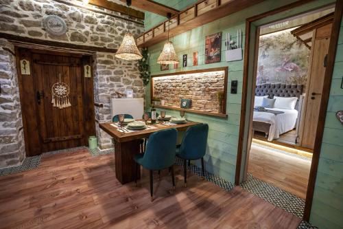 a room with a wooden table and blue chairs at Archontiko Theofanous 1915 in Tríkala