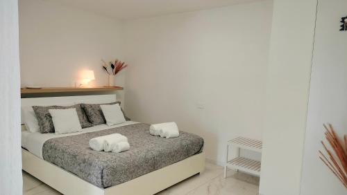 a white bedroom with a bed with two white pillows at CThomeRimini, appartamento Rimini Miramare in Rimini