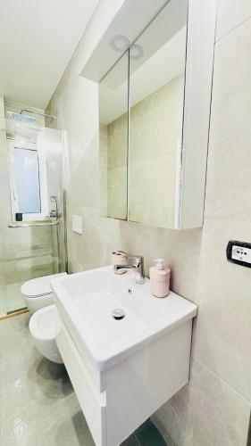 een witte badkamer met een toilet en een wastafel bij Blloku Luxury 2 bedroom apartment in Tirana