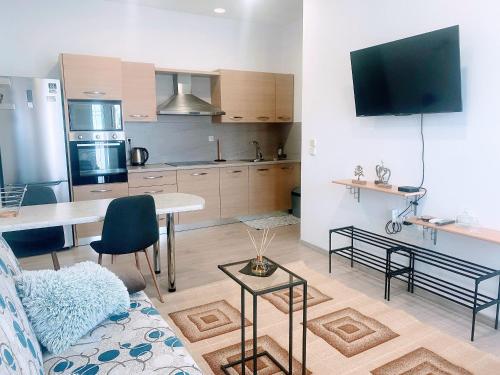 a kitchen and living room with a couch and a table at MariAggela's Cosy House in Theologos
