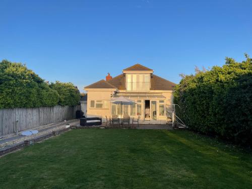 a large house with a lawn in front of it at 2100 Sq Ft Beach House with large garden in Earnley