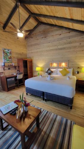 a bedroom with a large bed in a wooden room at Hotel Amigo Nicaragua in Nindirí