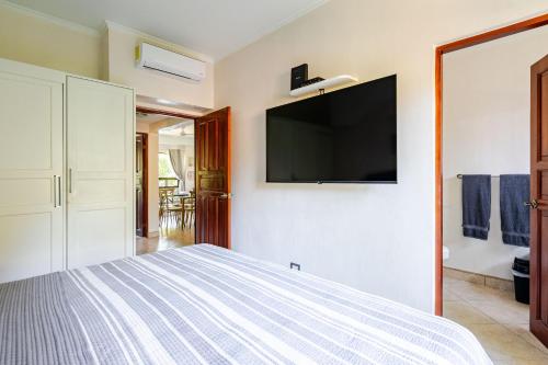 a bedroom with a bed with a flat screen tv on the wall at Luxury 2BR Escape near Tamarindo in Tamarindo