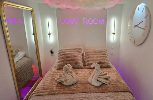 une chambre avec un lit avec des serviettes dessus dans l'établissement LoveRoom by LimousineLyonnaise, à Rive-de-Gier