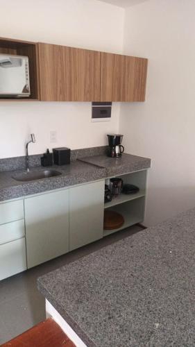 a kitchen with a sink and a counter top at Villa Naluri - Casa Yodo - Apartamento 1 quarto em Japaratinga in Japaratinga
