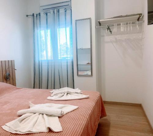 a bedroom with two towels on a bed with a mirror at MariAggela's Cosy House in Theologos