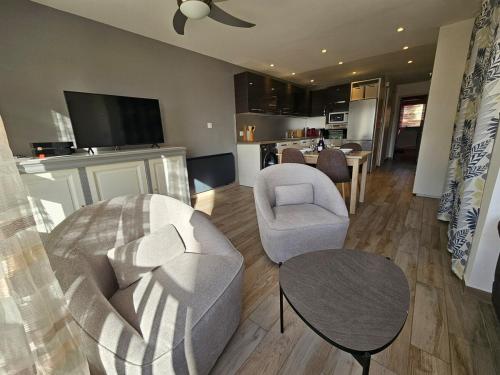 - un salon avec un canapé, une chaise et une table dans l'établissement Appartement moderne familial avec vue sur le port, au Cap d'Agde