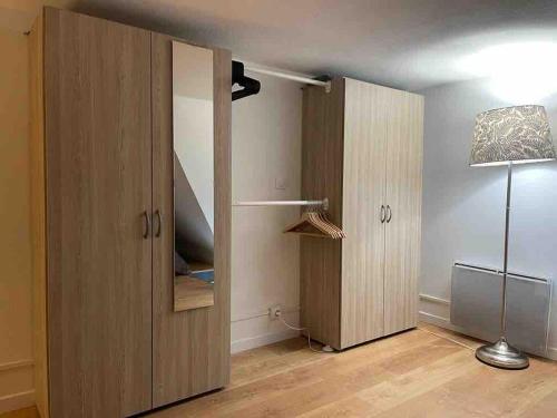 a room with two wooden cupboards and a lamp at Magnifique appartement avec mezzanine prés Thalasso in Cabourg