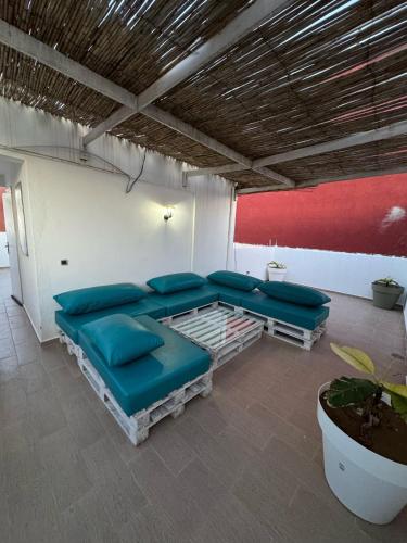 una sala de estar con sofás azules y una pared roja. en Asunfo surf, en Tamraght Ouzdar