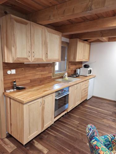 a kitchen with wooden cabinets and a stove top oven at Rekreačná chata in Banská Bystrica