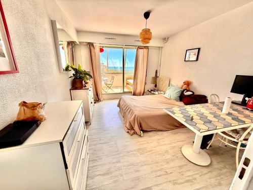 une chambre avec un lit et une table dedans dans l'établissement Studio au bord de la mer, à Mauguio
