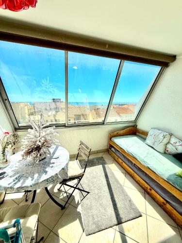 une chambre avec un lit, une table et une fenêtre dans l'établissement Studio au bord de la mer, à Mauguio