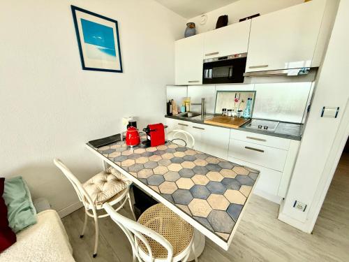 une cuisine avec une table et des chaises dans une pièce dans l'établissement Studio au bord de la mer, à Mauguio