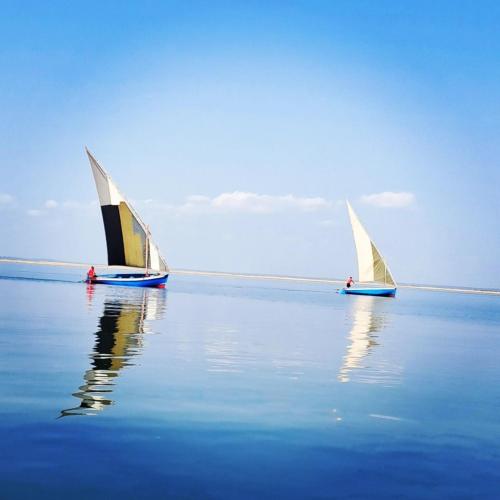 two sailboats in the water on a body of water at Coral Villa - Beachfront Villa with Private Pool by Karula in Inhambane