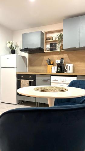 une cuisine avec une table et un comptoir dans l'établissement Charmant Studio Rénové - Cœur Historique de Grasse - Climatisé & Tout Confort, à Grasse