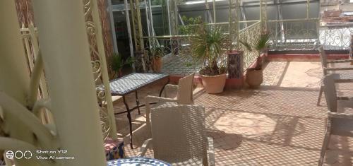a balcony with chairs and tables and potted plants at Hotel Bab Boujloud in Fès