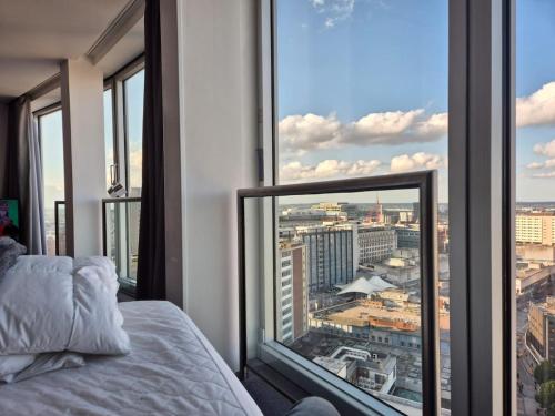 een slaapkamer met een bed en uitzicht op de stad bij 25 World Famous Rotunda 18th floor skyline views in Birmingham