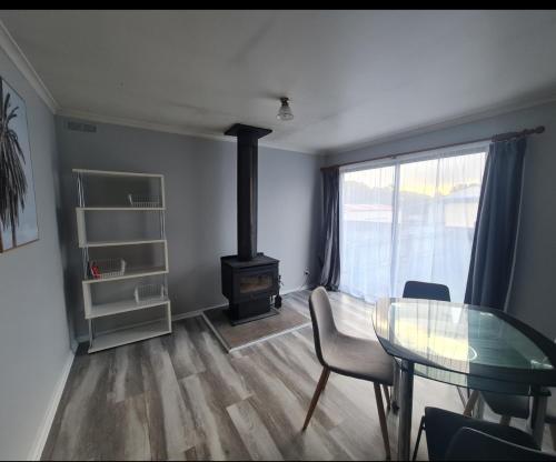 a living room with a glass table and a wood stove at Zeehan 3 bedroom house in Zeehan