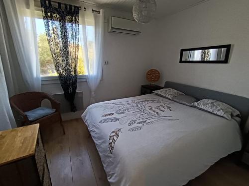 une chambre avec un lit avec une couette blanche dans l'établissement Apparement Duplex avec jacuzzi, à Saint-Georges-dʼOrques